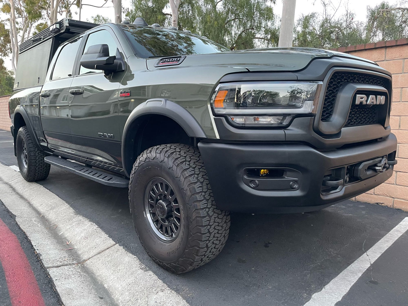 This dark green Ram 2500 pickup, equipped with an overlanding truck camper, is ideal for an RV rental adventure.