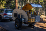 Overland Equipment teardrop RV rental setup with outdoor kitchen, ready for camping in a forest. Lexus SUV attached.