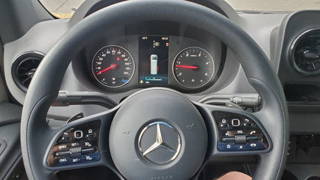 Dashboard of a Mercedes-Benz Sprinter, an RV rental, showing gauges, DEF level, and steering wheel with controls.