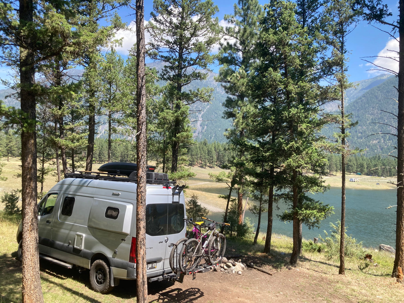 Beautiful camper van (rv rental) parked lakeside with mountain bikes. Ideal for serene camping & outdoor exploration.