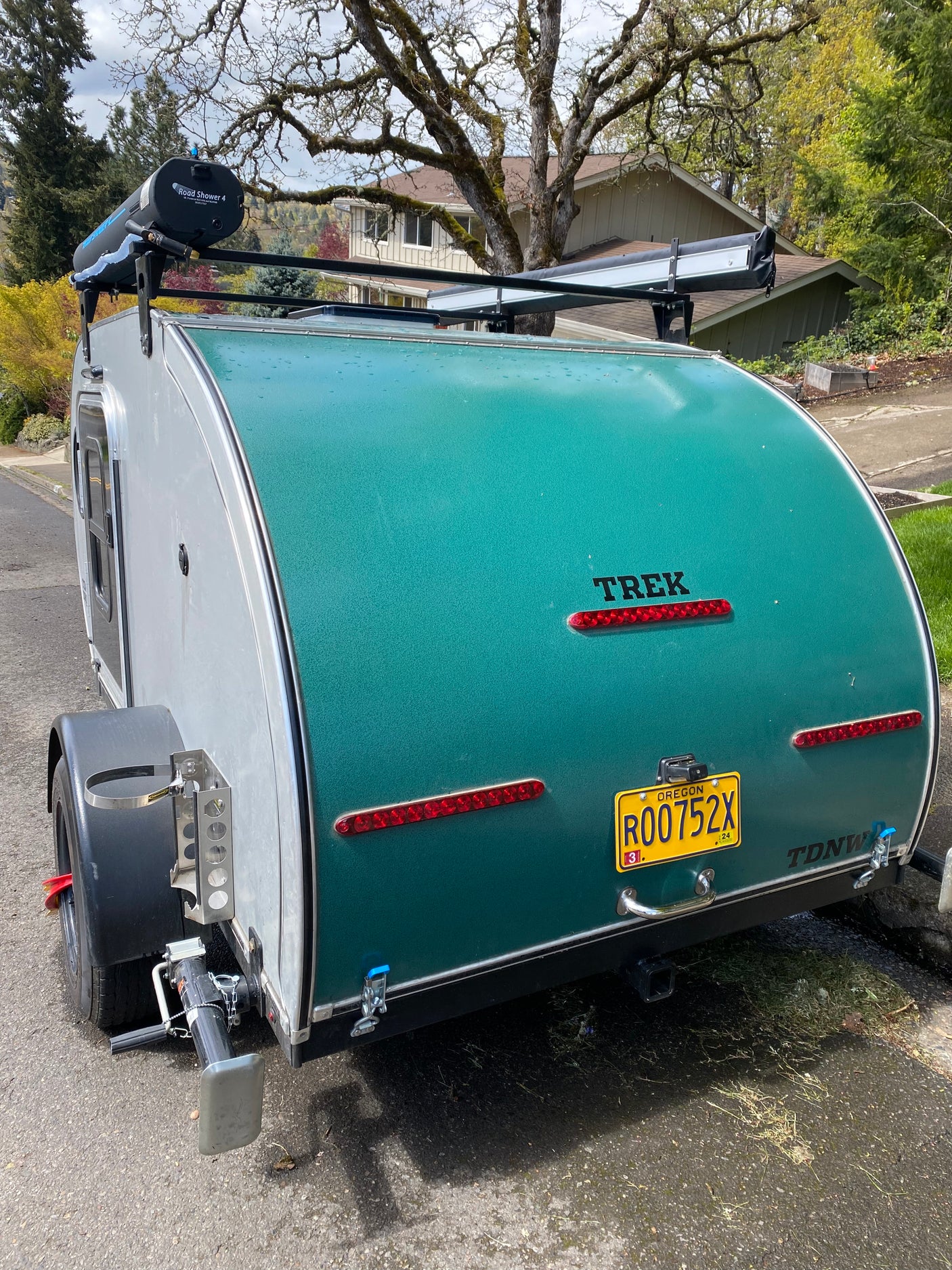 TREK teardrop camper rear view, an excellent rv rental choice. Note the roof shower, Oregon plate, and stabilizer jack.