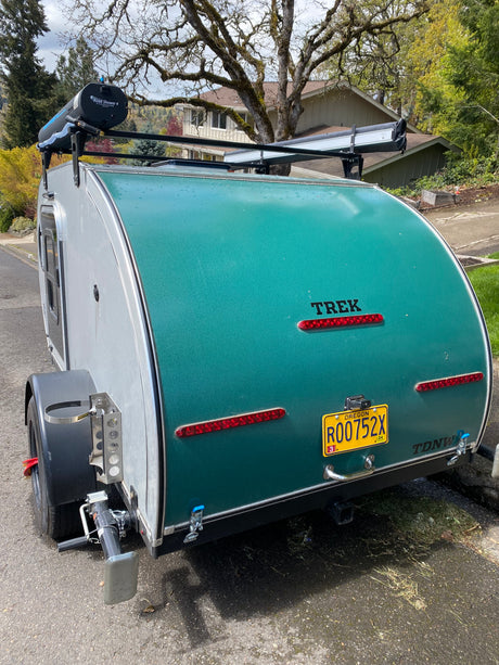 TREK teardrop camper rear view, an excellent rv rental choice. Note the roof shower, Oregon plate, and stabilizer jack.