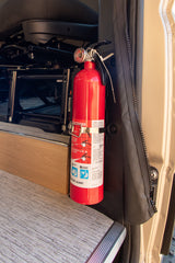 Safety first for your RV rental: A First Alert fire extinguisher securely mounted in an RV interior, ready for use.