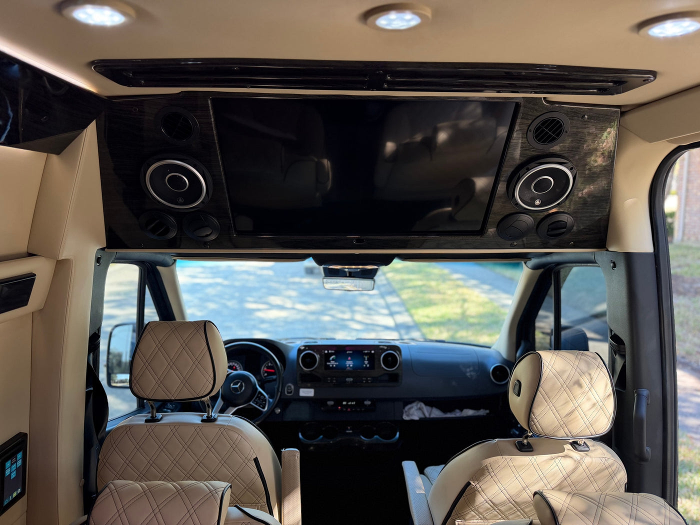Inside an rv rental: A sleek interior with a large entertainment display, integrated speakers, and luxurious diamond-stitched seats. — photo 12