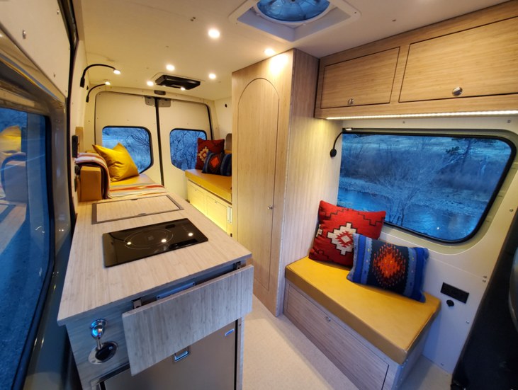  parked on a gravel road by a mesa.|A light-colored Sprinter van — photo 1
