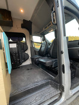 RV rental camper van interior: Front seats, durable floor, custom build, and adaptable space for travel.