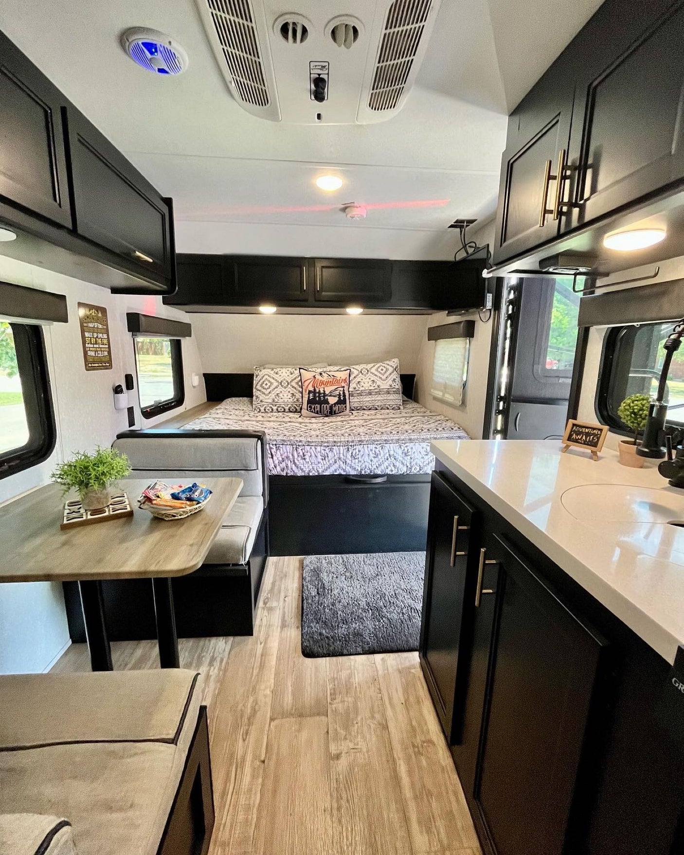 Explore this inviting RV rental interior: a comfortable bed, dining area, and full kitchen make for a perfect mobile home.