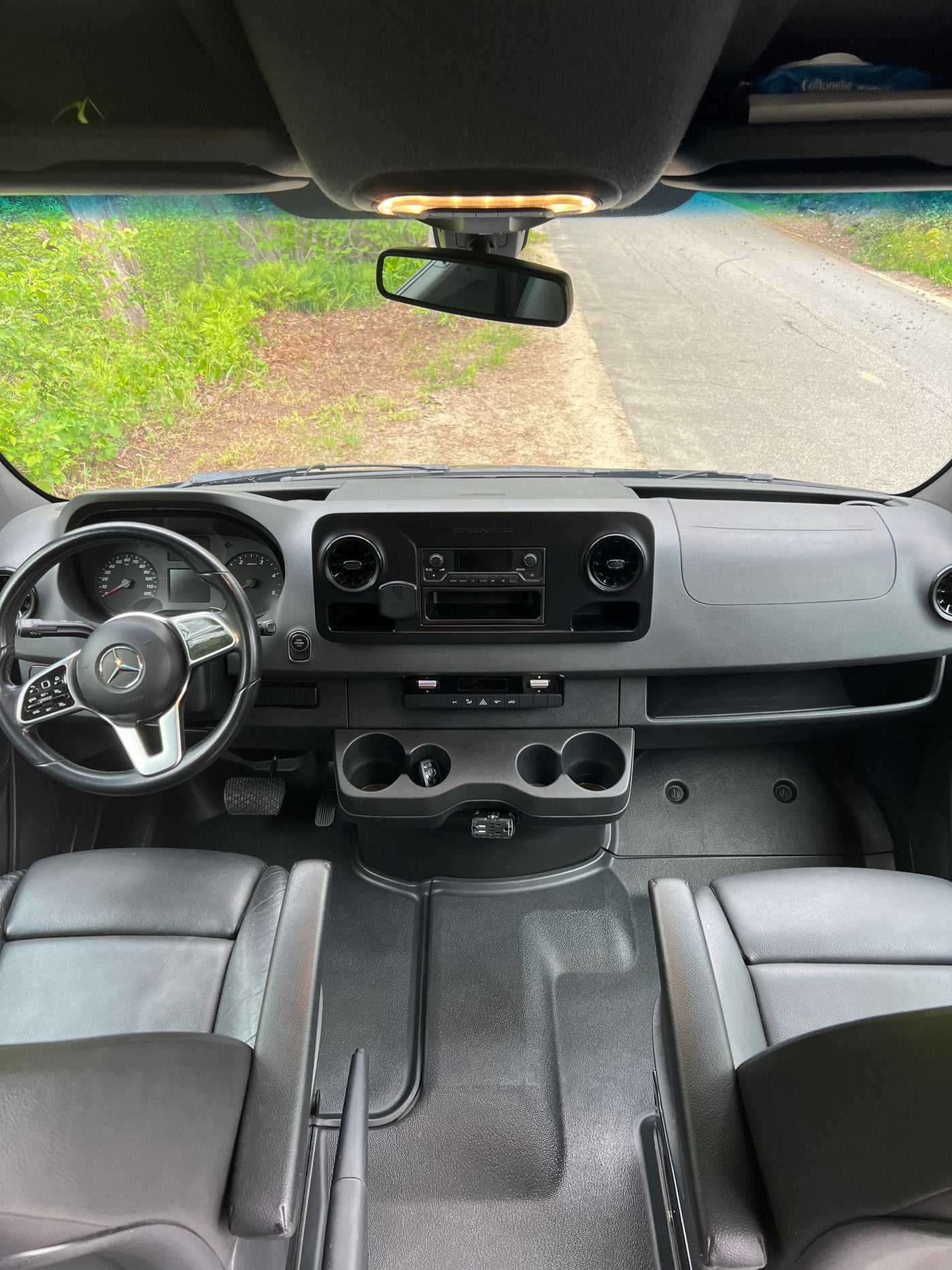 Inside a Mercedes Sprinter van, perfect for an RV rental adventure. Driver's view of the dashboard, steering wheel, and front cabin. — photo 15