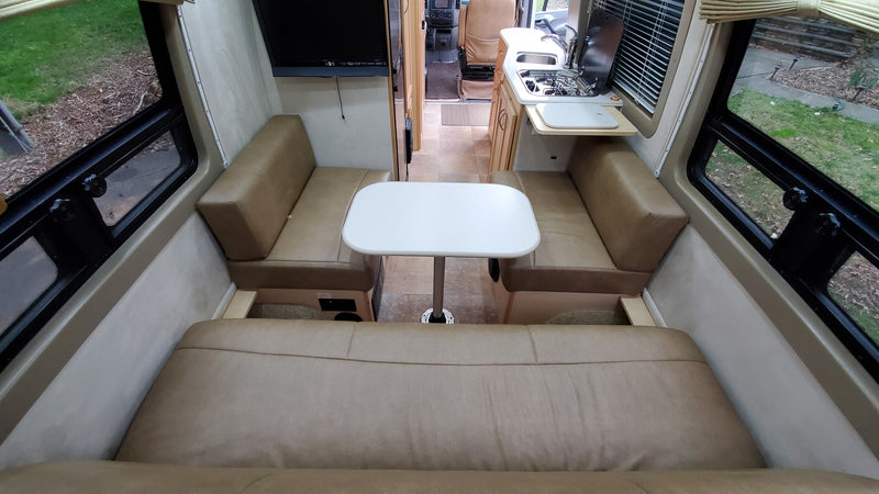  and cozy rear lounge seating.|RV rental kitchen: light counter with sink & stove — photo 11