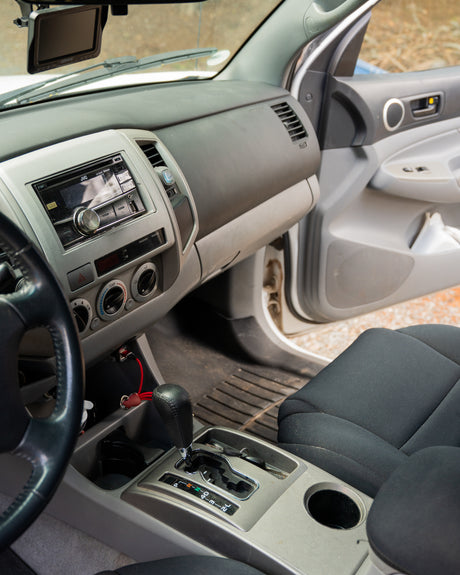 Front interior of an RV rental: dashboard, steering wheel, gear shift, and passenger seat shown.