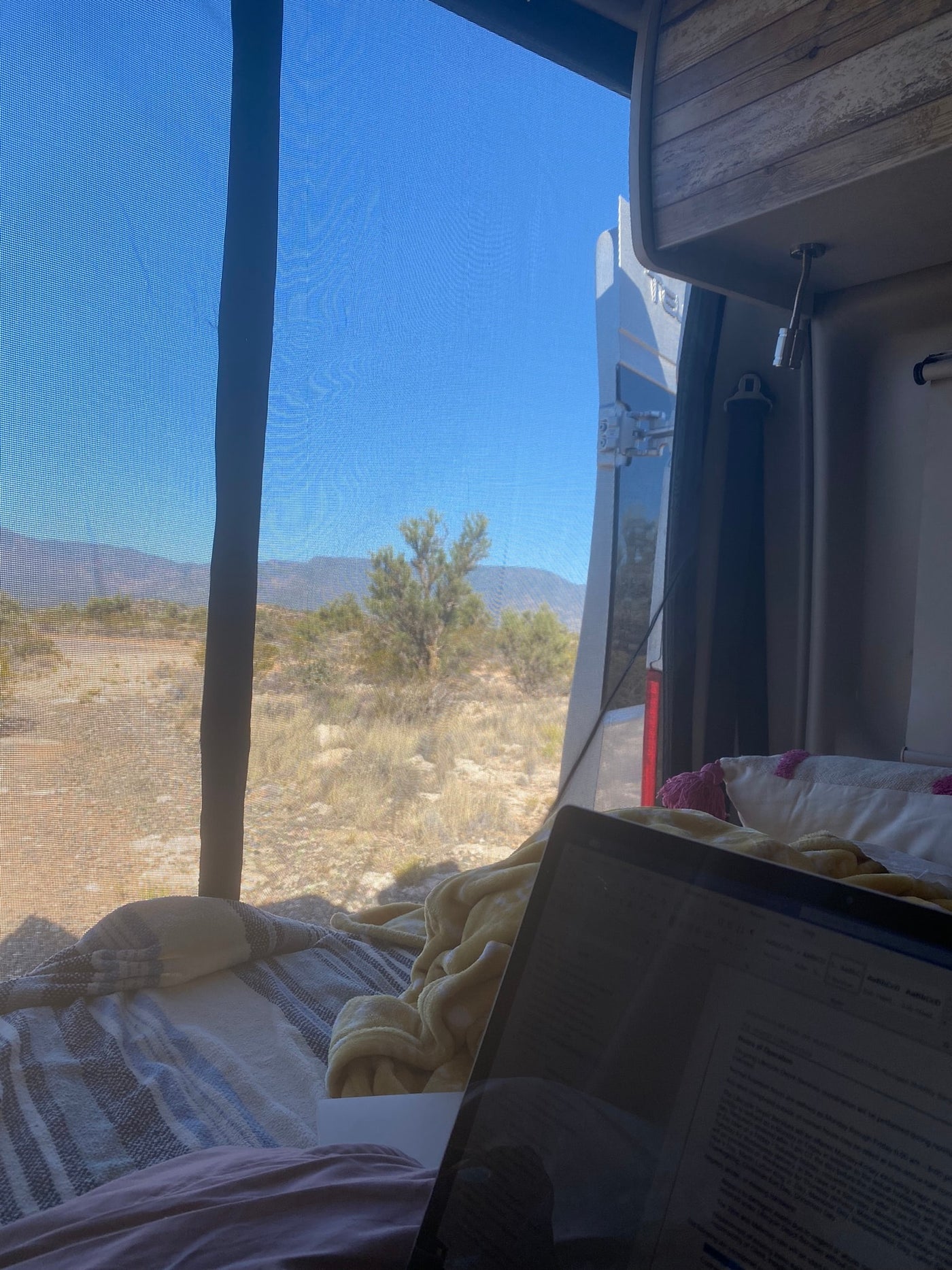 Enjoying remote work from an RV rental, with a laptop overlooking a scenic desert and mountain landscape. — photo 18