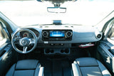 Interior view of a modern RV rental cockpit, showing the dashboard, steering wheel, infotainment system, and front seats.