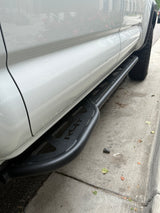 White vehicle with rugged black RLT running boards, parked on concrete. An ideal accessory for any RV rental adventure.