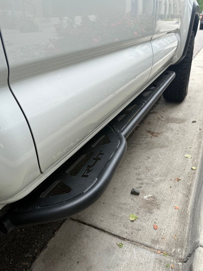 White vehicle with rugged black RLT running boards, parked on concrete. An ideal accessory for any RV rental adventure. — photo 18