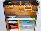 Compact, organized RV rental kitchen setup with stove, spices, and smart storage for camping adventures.