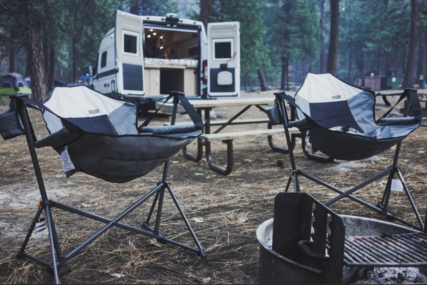  with iconic Half Dome and towering pine forests in the background. Great for scenic travel.|RV rental: Camper van's open rear doors showcase a cozy interior with a bed & storage — photo 7