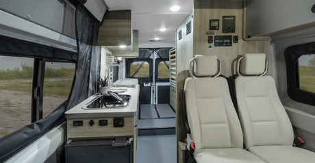 RV rental: Camper van interior featuring a modern kitchen, front seats, and a convertible rear living area.