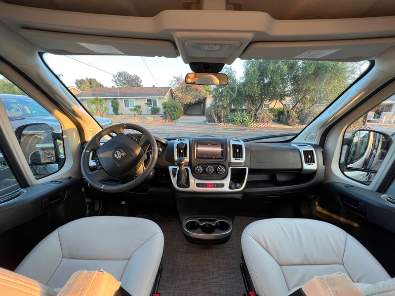  parked in a desert campsite amidst large rock formations and an extended awning.|Spacious RV rental interior with open doors — photo 9