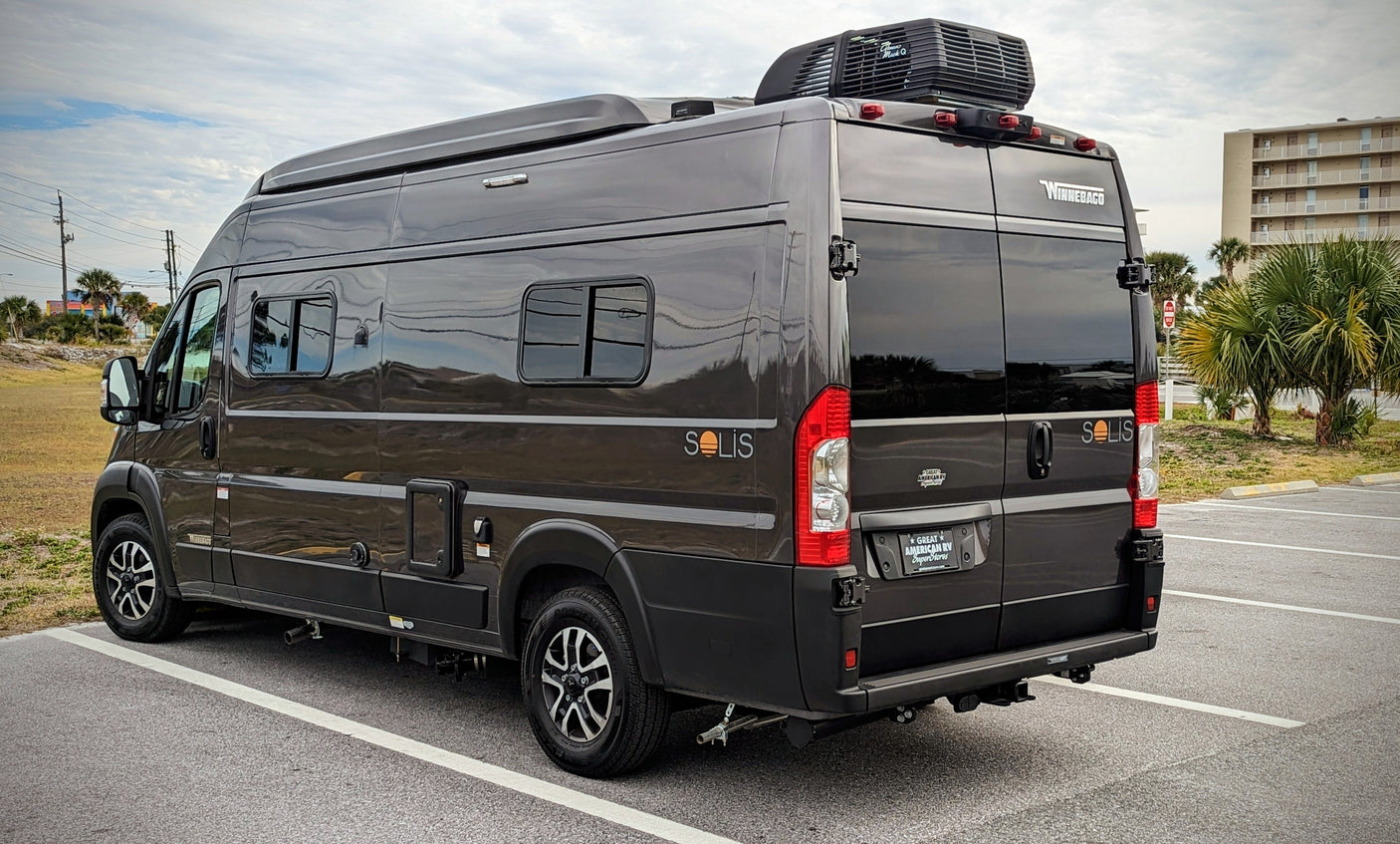 Dark gray Winnebago Solis camper van with rooftop AC, ideal for an RV rental or road trip adventure.