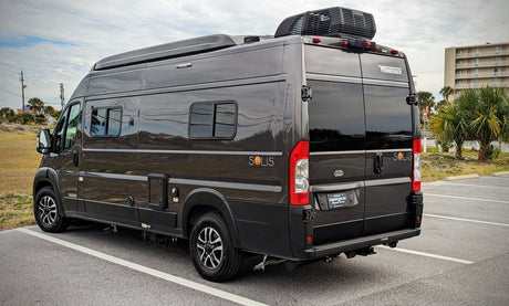 Dark gray Winnebago Solis camper van with rooftop AC, ideal for an RV rental or road trip adventure.