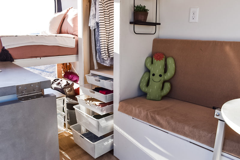 Cozy RV rental interior showcasing smart storage with pull-out drawers, a comfortable bed, and inviting bench seating. — photo 13