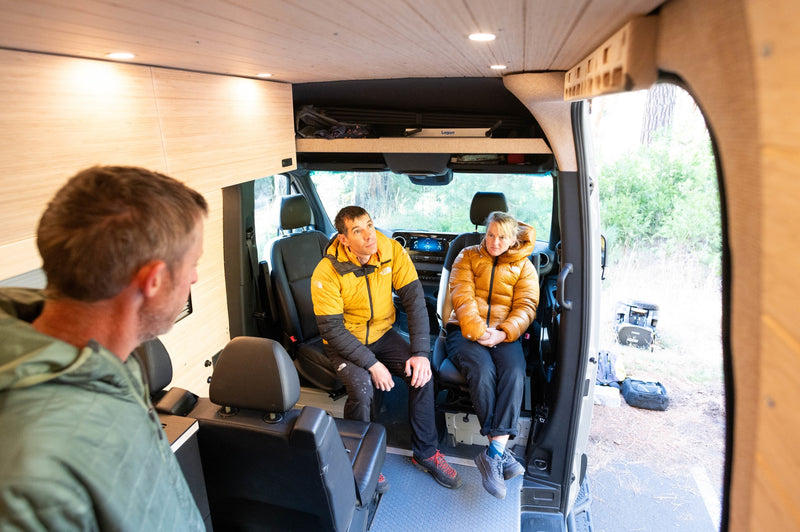 Two passengers in an RV rental van, dressed for outdoor adventure, are seated in the versatile interior. — photo 5