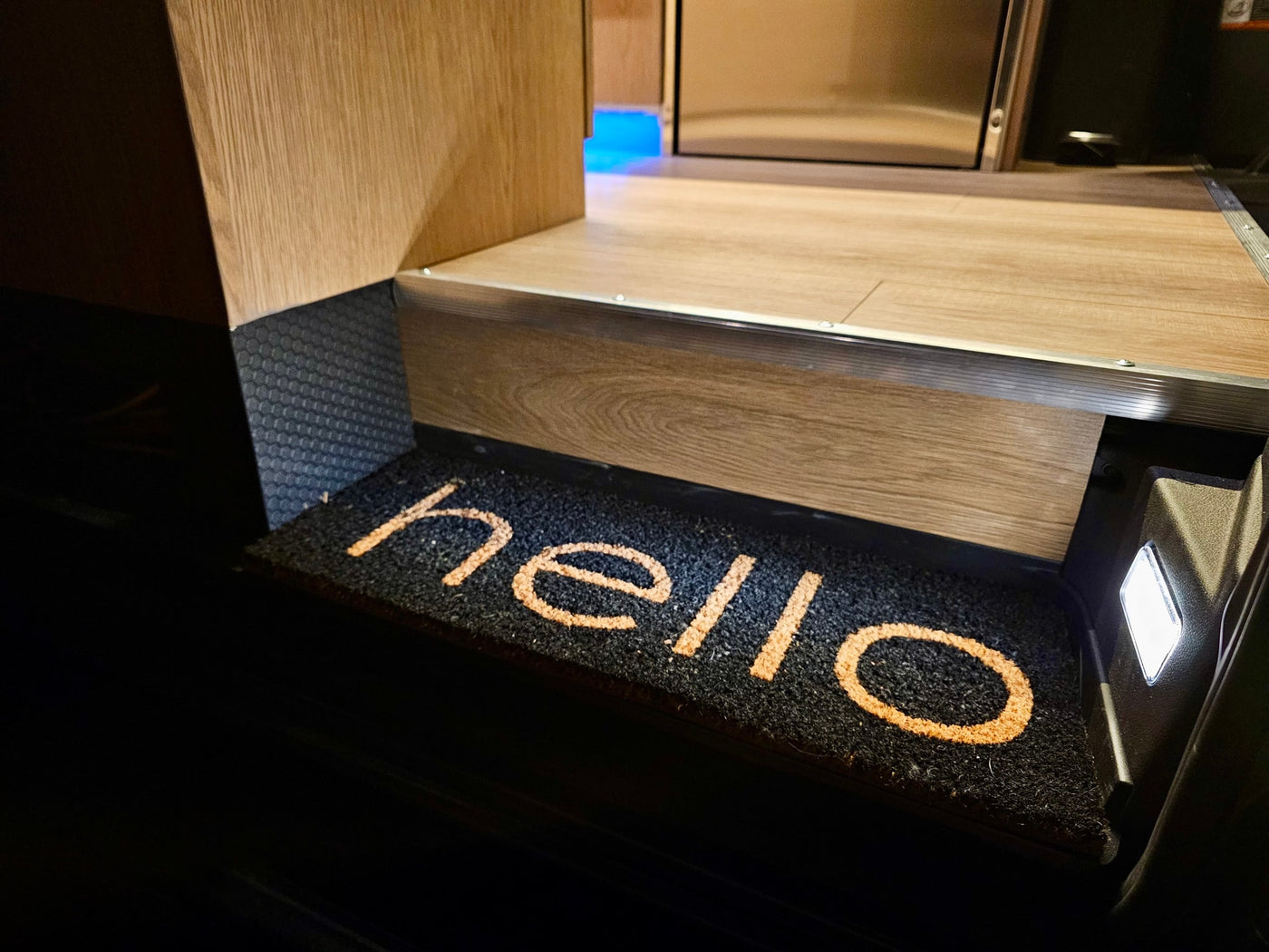Welcome aboard! An inviting RV rental interior features a "hello" doormat illuminated by a step light. — photo 7
