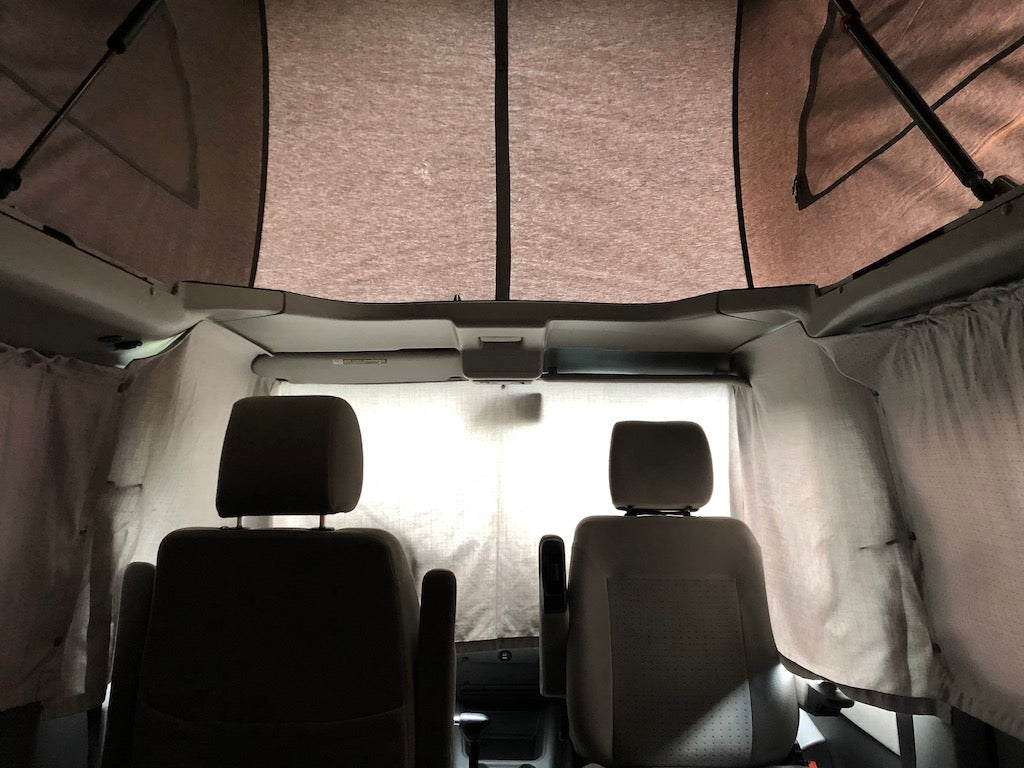 Interior of an rv rental pop-top camper van, featuring front seats, privacy curtains, and a spacious elevated sleeping area. — photo 20