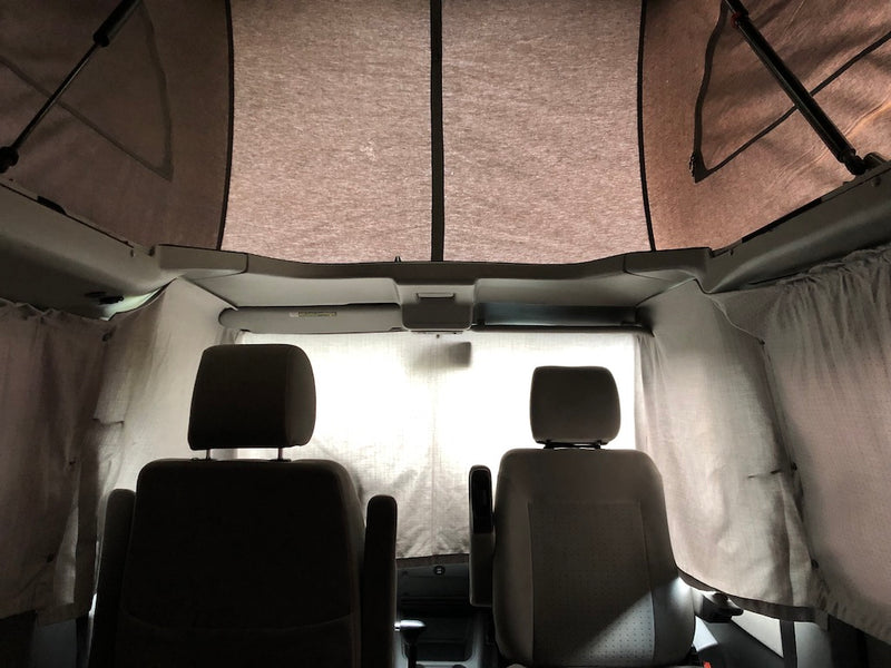 Interior of an rv rental pop-top camper van, featuring front seats, privacy curtains, and a spacious elevated sleeping area. — photo 20