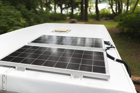 Two solar panels on a white RV roof, wired for power. Perfect for your next RV rental adventure.