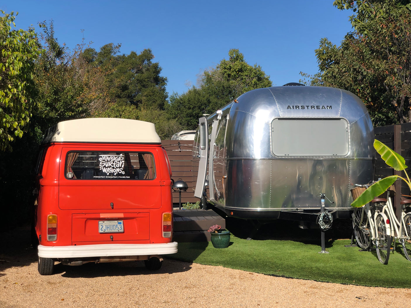 Vintage VW camper van and an Airstream travel trailer, likely available for RV rental.