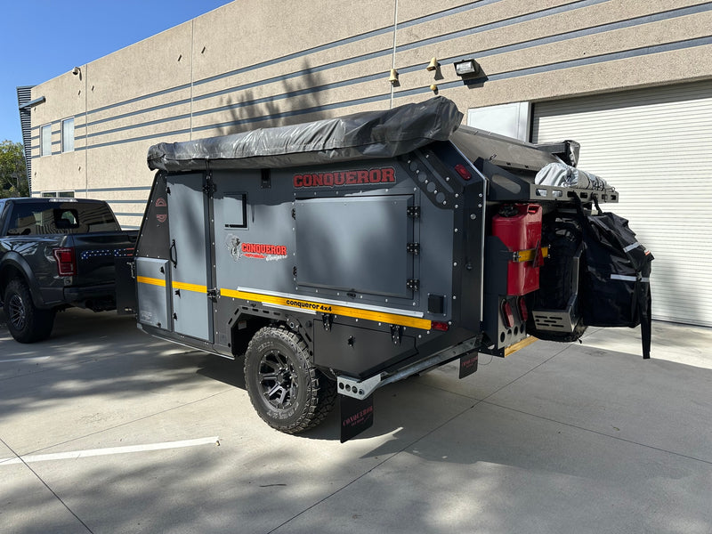 Rugged Conqueror off-road camper trailer attached to a truck, ready for your RV rental overland adventure. — photo 8
