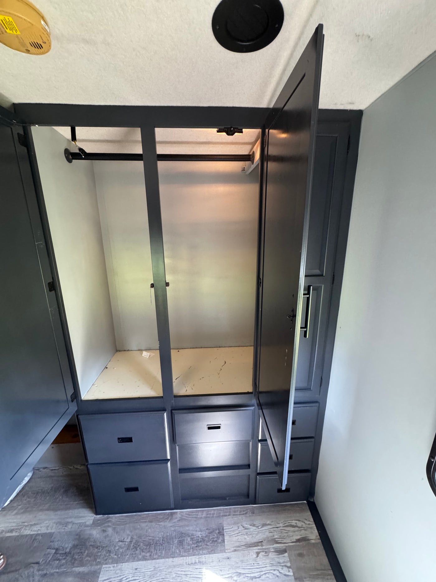 Spacious gray wardrobe with hanging rod and drawers open in an rv rental, ready for clothes and storage. — photo 12