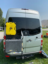 Back of an rv rental Sprinter van with overland gear: Rotopax, Pelican case, shovel on a modular rack for adventures.