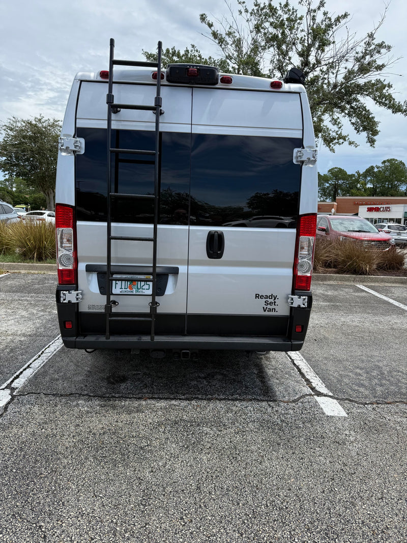  next to a comfy cushioned seat under a wooden countertop.|Close-up of a silver RV rental van — photo 13