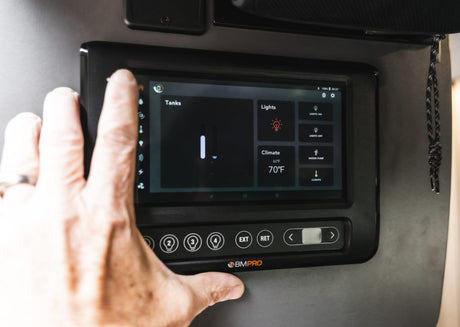 User interacts with an RV rental's BMPRO smart control panel, managing tank levels, lights, and climate settings.