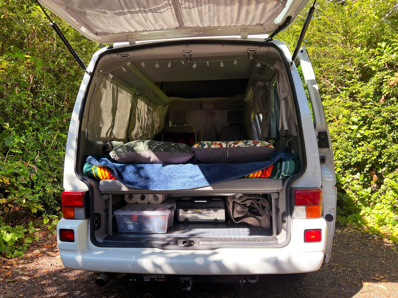  parked on a wooded trail under a sunny sky. Perfect for road trips!|Open rear hatch of an RV rental — photo 2