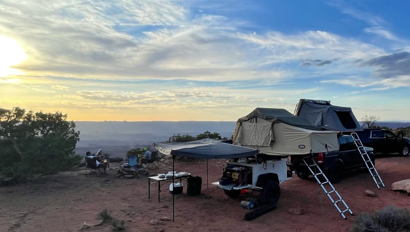 Overlanding adventure! Rooftop tents and trailer setups offer off-grid camping, a unique alternative to RV rental, at sunset.