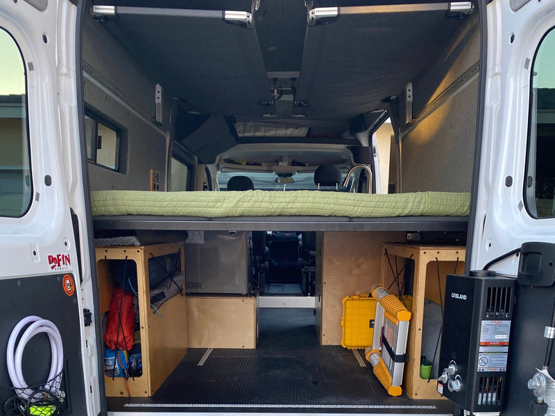 RV rental: Van interior with an elevated bed, under-bed storage units, and a Gasland water heater, perfect for camping. — photo 9