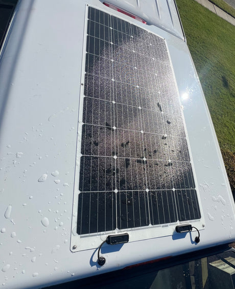 This RV rental features a rooftop solar panel, seen here sparkling with water droplets after a recent wash.