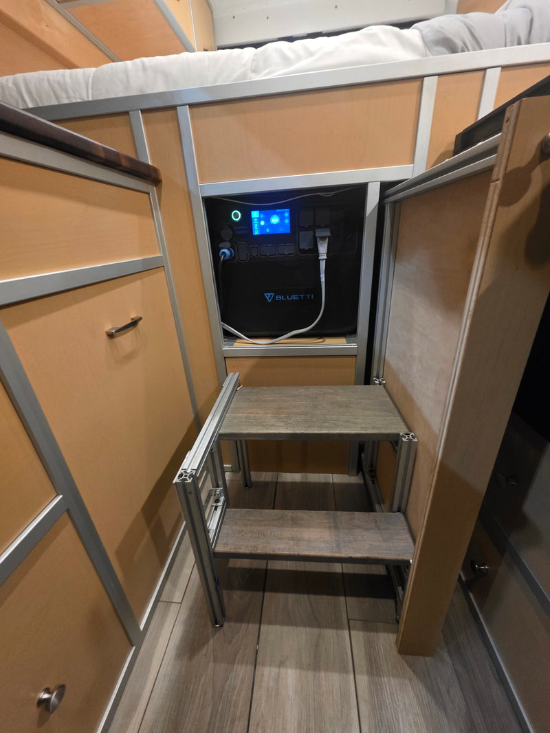 Bluetti power station, plugged in and integrated into a compact RV rental interior, with a custom two-step ladder & bunk bed. — photo 6