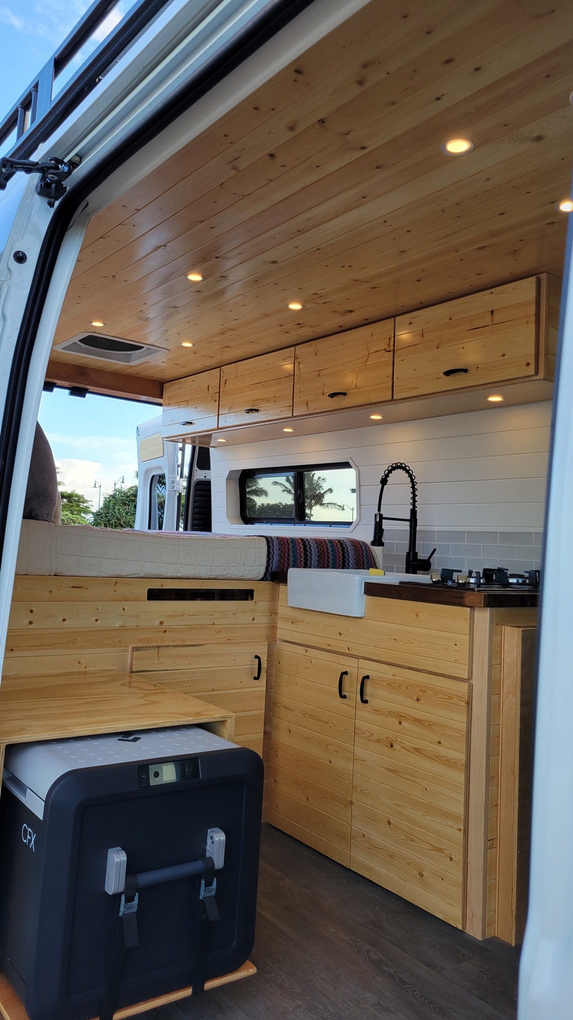  and cooler on grey wood floor.|Modern RV rental interior: wood ceiling — photo 7