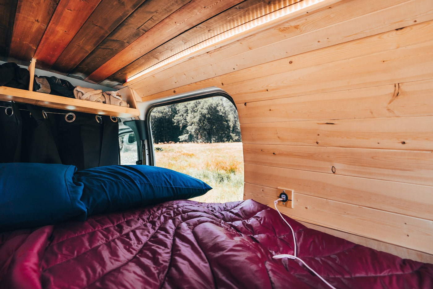  beside red bedding.|Relax in your RV rental with a comfy bed — photo 7