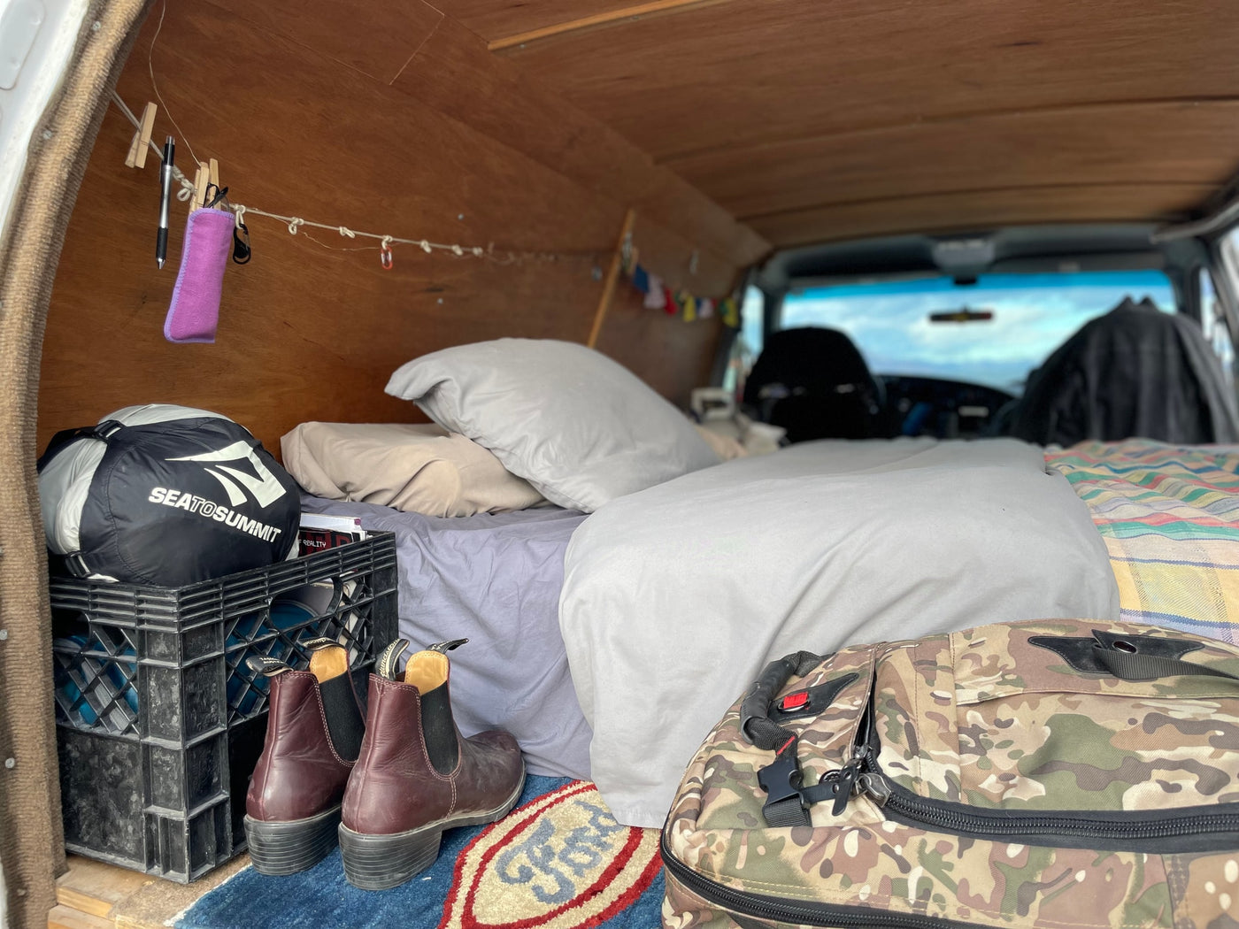 Cozy RV rental interior: bed, Sea to Summit gear, and smart storage solutions for mobile adventures. — photo 2