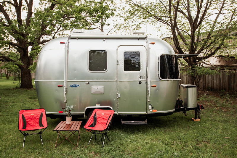 Experience glamping with this Airstream RV rental! A shiny silver travel trailer with red camping chairs awaits your outdoor adventure. — photo 19
