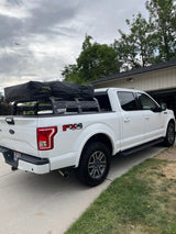 White Ford F-150 truck with rooftop tent for camping, a versatile alternative to an RV rental.