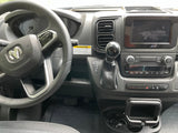 Driver's view of an RV rental dashboard, showing the steering wheel, infotainment screen, gear shifter, and controls inside the camper van.