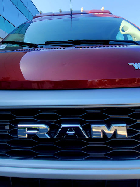 Front view of a red Ram heavy-duty truck, its RAM grille prominent, suitable for rv rental.