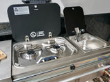 RV rental outdoor kitchen: stainless steel compact unit with two-burner stove and sink for camping.