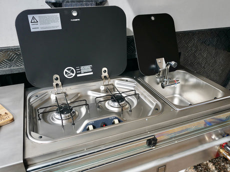 RV rental outdoor kitchen: stainless steel compact unit with two-burner stove and sink for camping.
